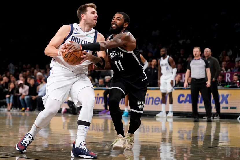 Dallas Mavericks guard Luka Doncic, left, drives against Brooklyn Nets guard Kyrie Irving...