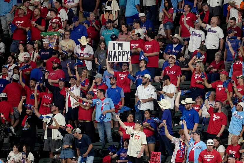 A fan holds up a sign that reads "I'm Happy", at the start of a baseball game between the...