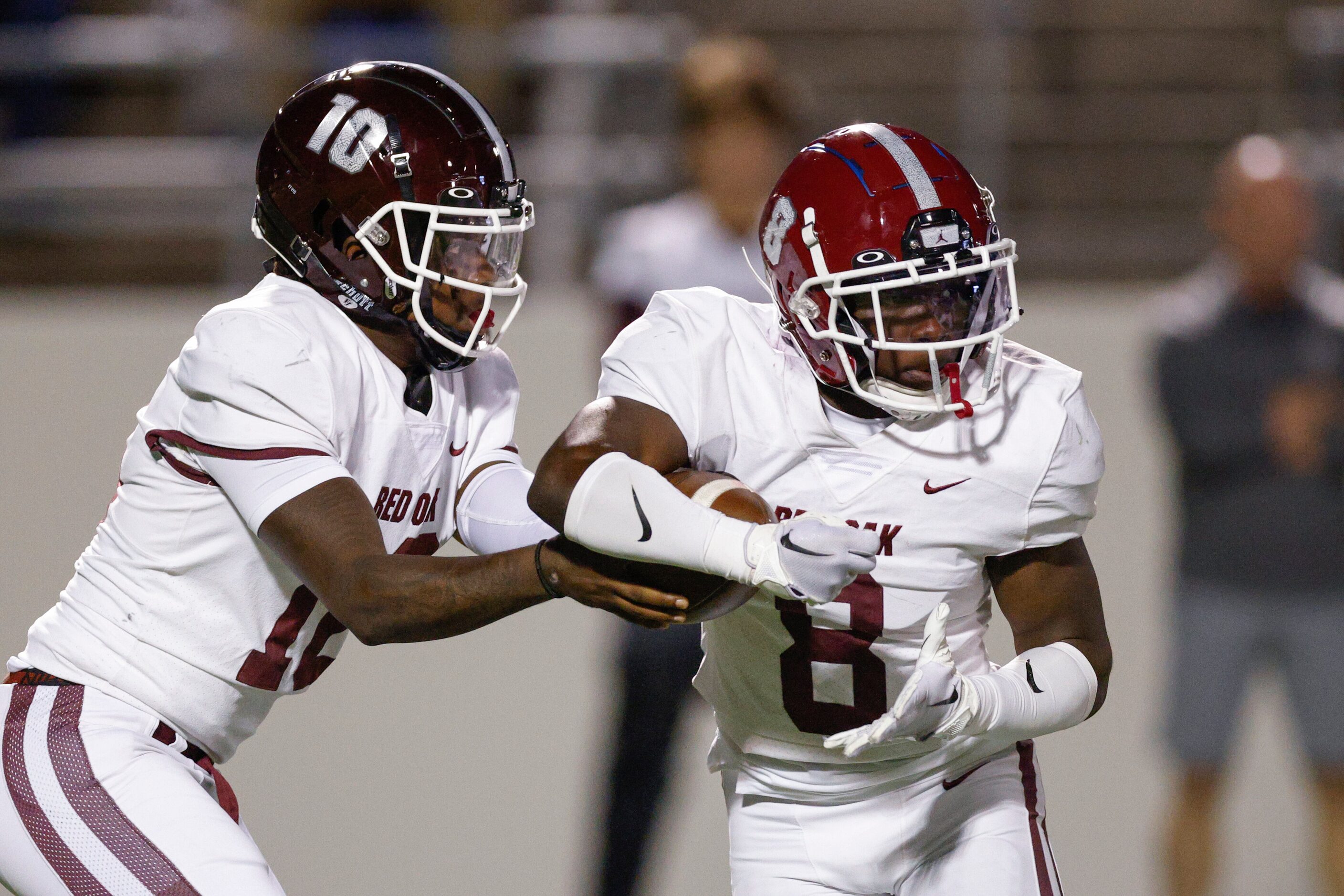 Red Oak quarterback Jaylon Robinson (10) hands the ball to running back Moses Martindale (8)...