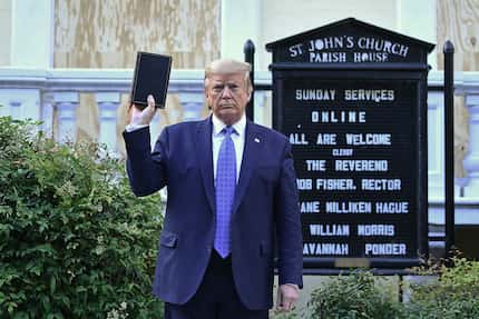 President Donald Trump holds up a Bible outside of St John's Episcopal church across...