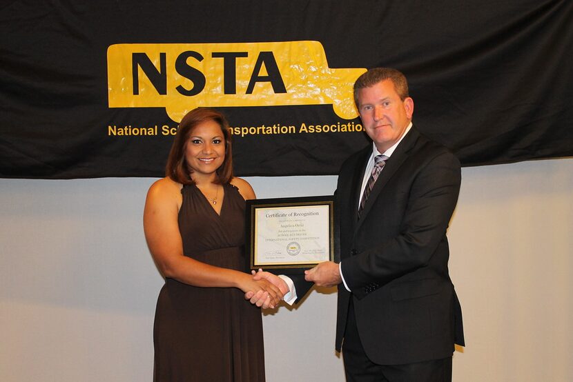 
Angie Ortiz receives a certificate from Tim Flood, president of the National School...