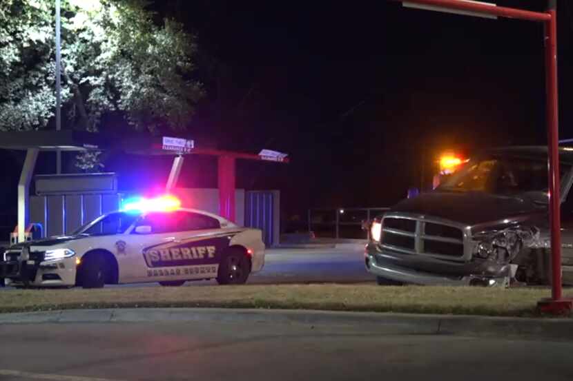 A Dallas County sheriff's vehicle is parked near a pickup truck that was involved in a crash...