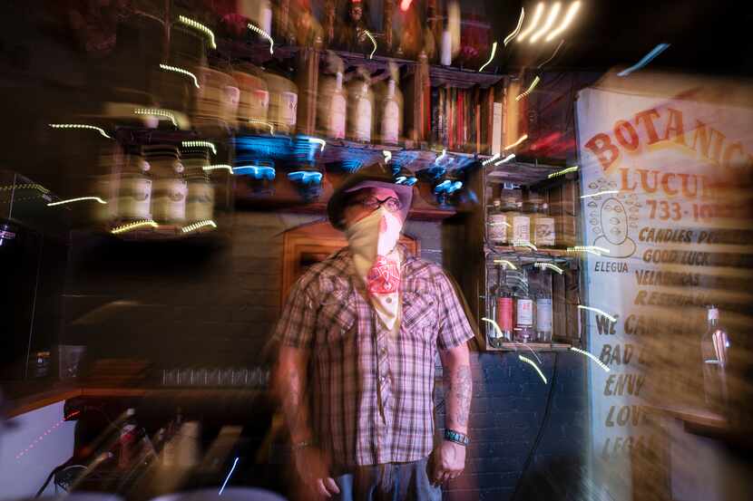 Co-owner Shad Kvetko photographed with a slow camera shutter behind the bar at the Spirits...