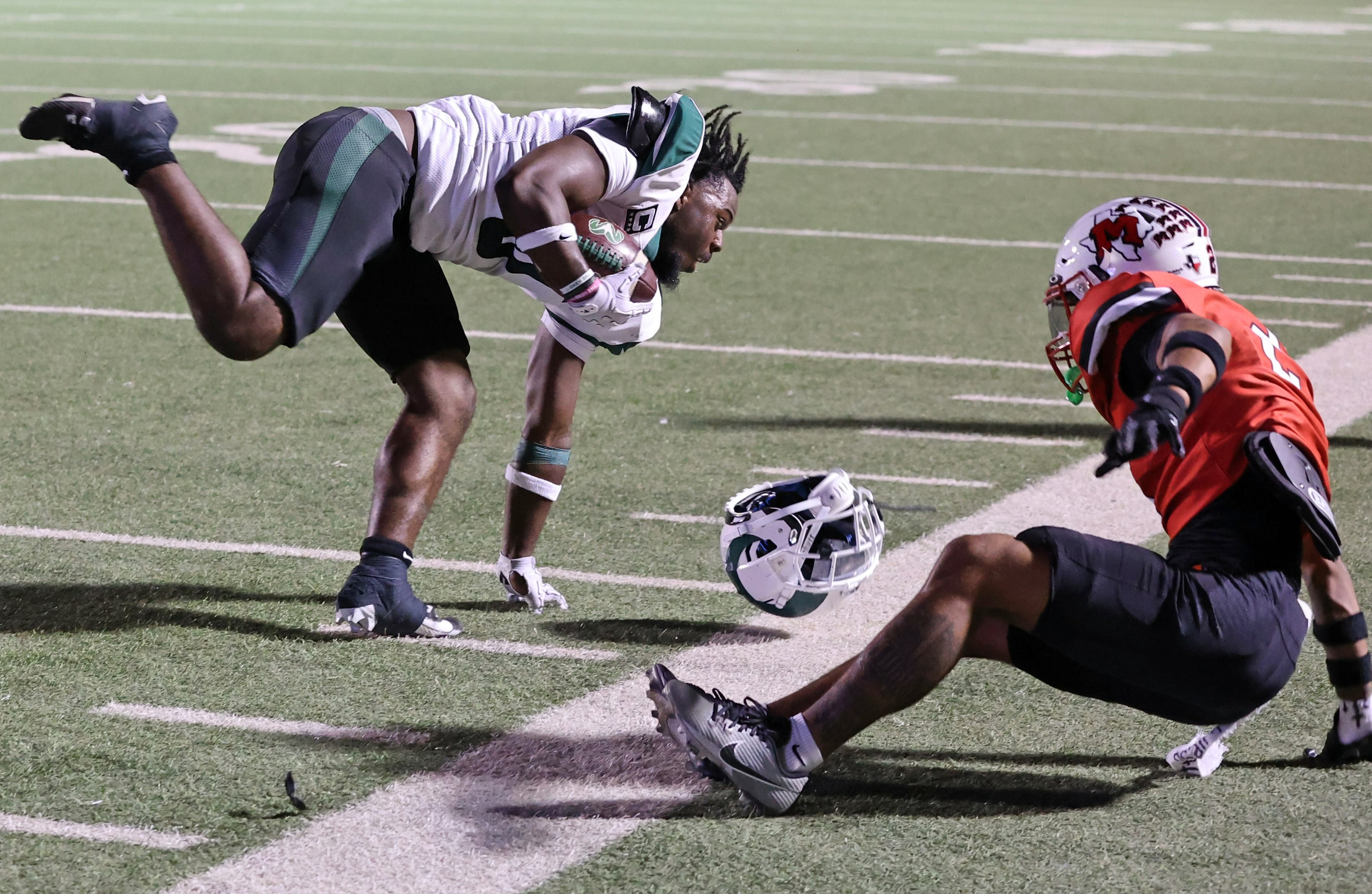 Richardson Berkner High RB Donte Doyle (0) holds onto the ball, but loses his helmet, after...