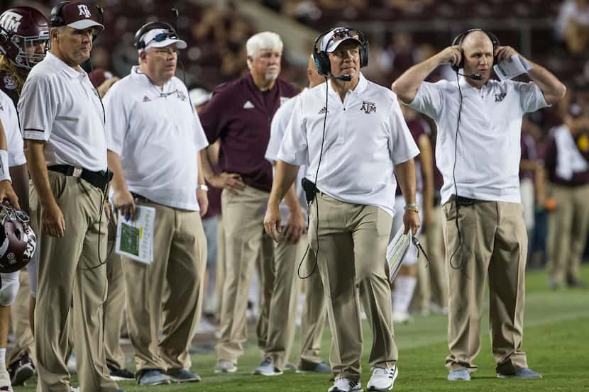 Texas A&M Aggies head coach Jimbo Fisher stands on the sidelines with his coaching staff...