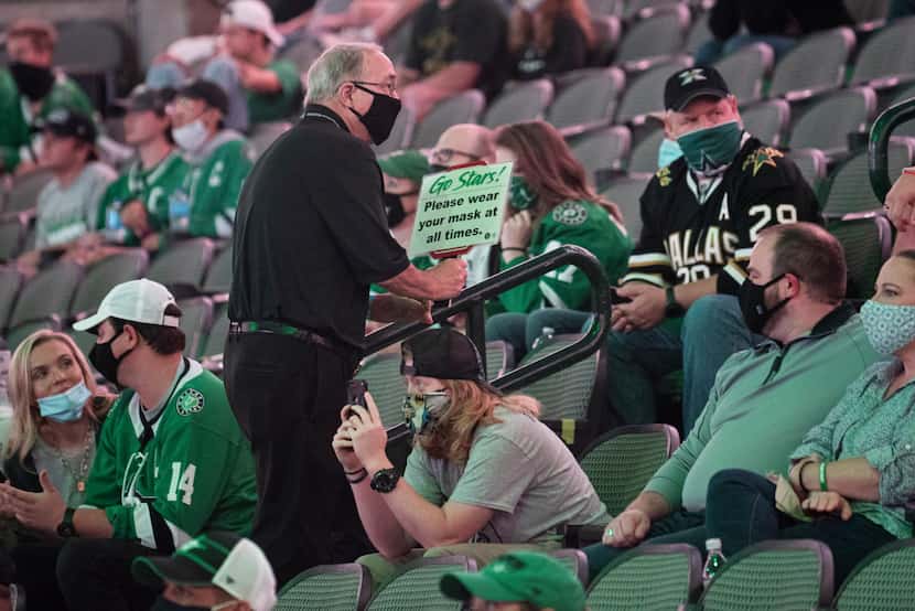An usher informs Dallas Stars fans to wear their face mask during a watch party at the...