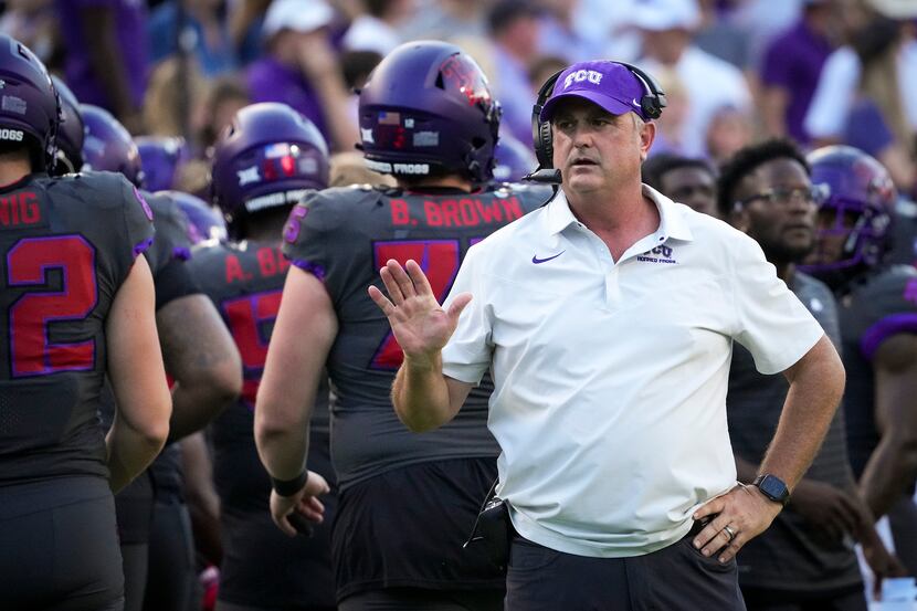 TCU head coach Sonny Dykes motions to his players on the bench during the second half of an...