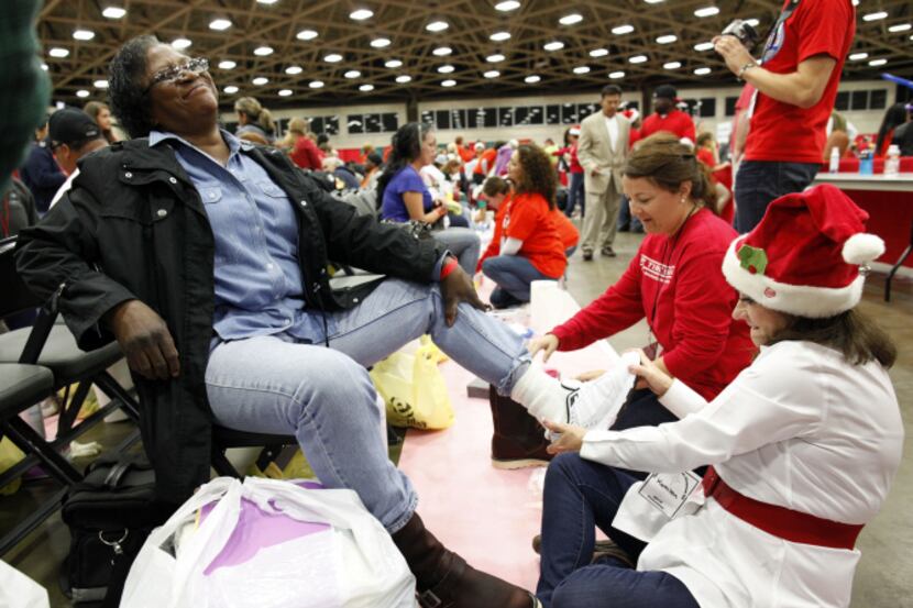 Volunteer Kathleen Turner helped Earnestine Hadnot try on a pair of shoes at Christmas Gift...