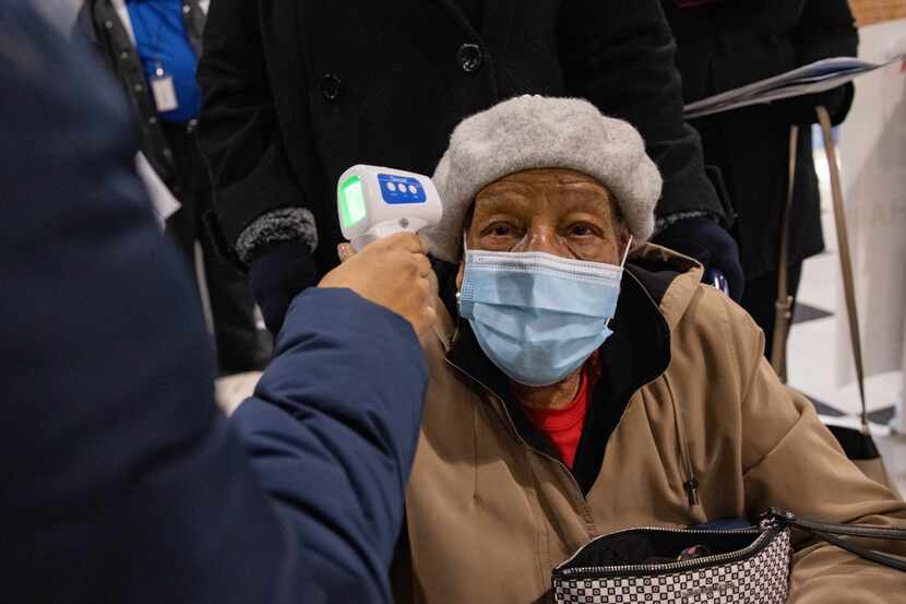 Mae Jackson, 99, has her temperature checked before entering to receive the COVID-19 vaccine...