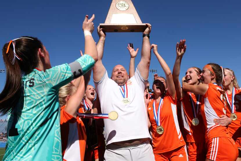  Celina head coach Alexander Adams proudly raises the Class 4A state championship trophy as...