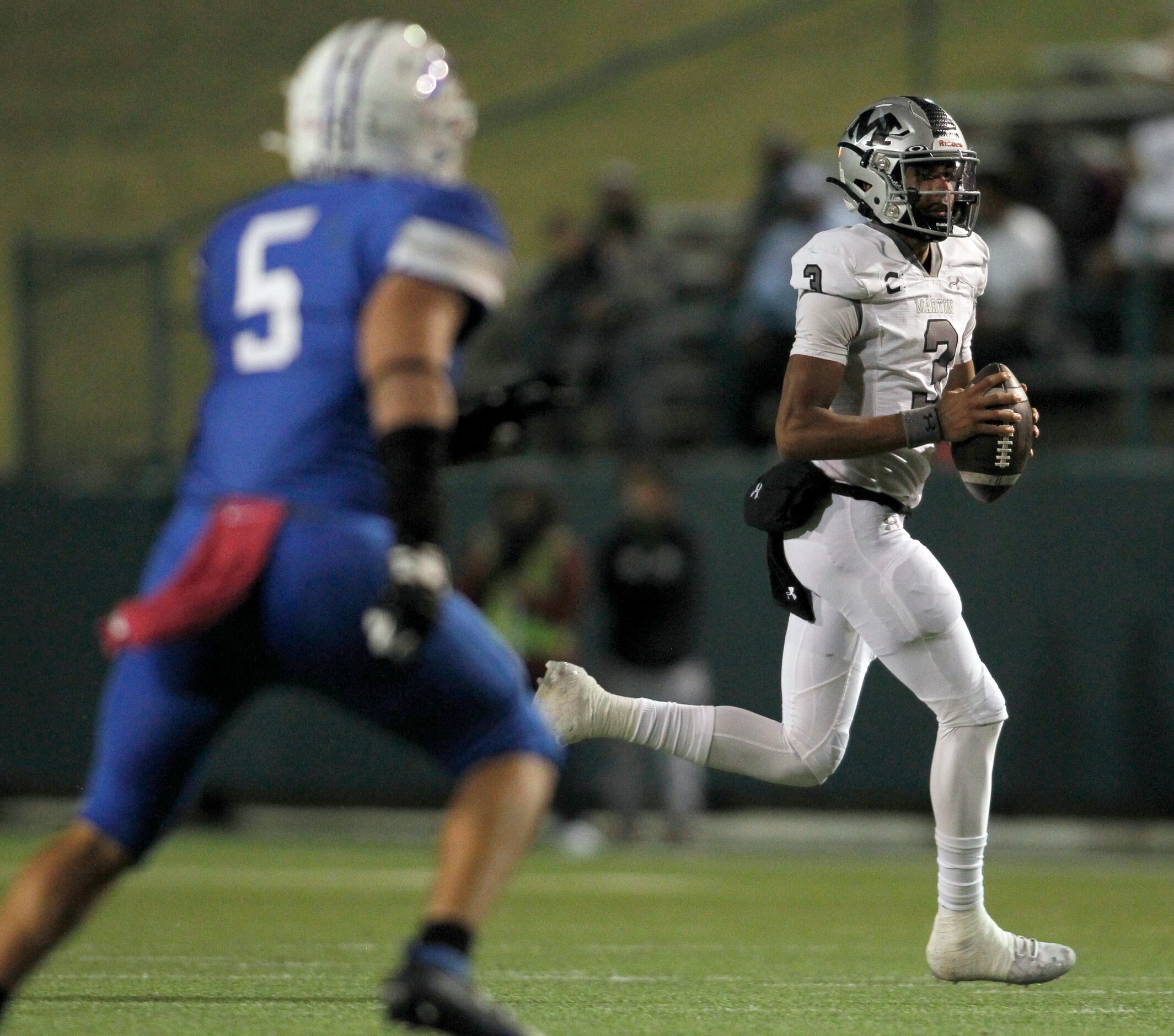 Arlington Martin quarterback Cydd Ford (3) rolls out on a quarterback keeper as he is...