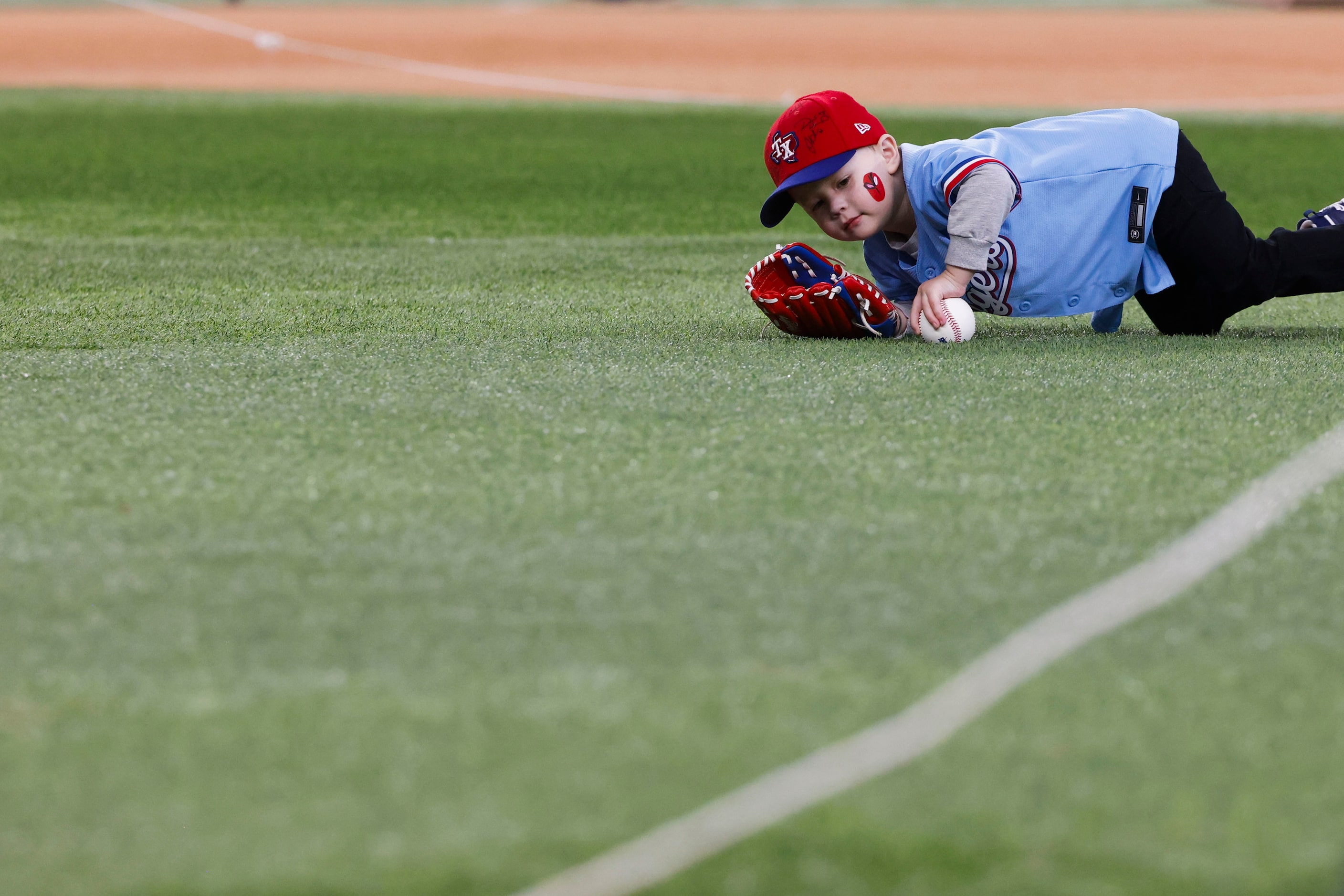 Cain Chandler, 3, collects his ball after he throws a pitch from the pitcher’s mound during...