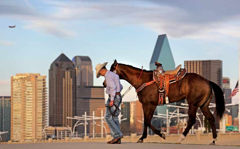 Andrew Salas,who was having his senior portraits taken, walks with his horse on the Trinity...