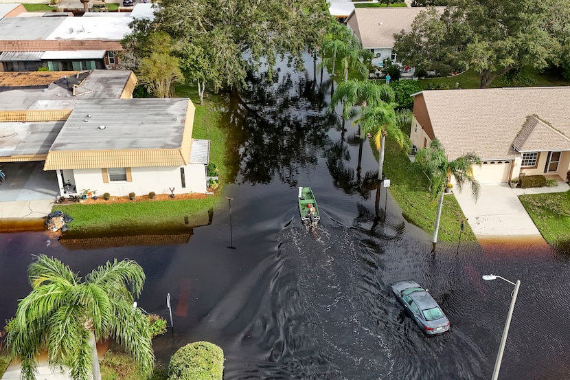 A member of the Pasco County Sheriff's Office goes out to help residents trapped in their...