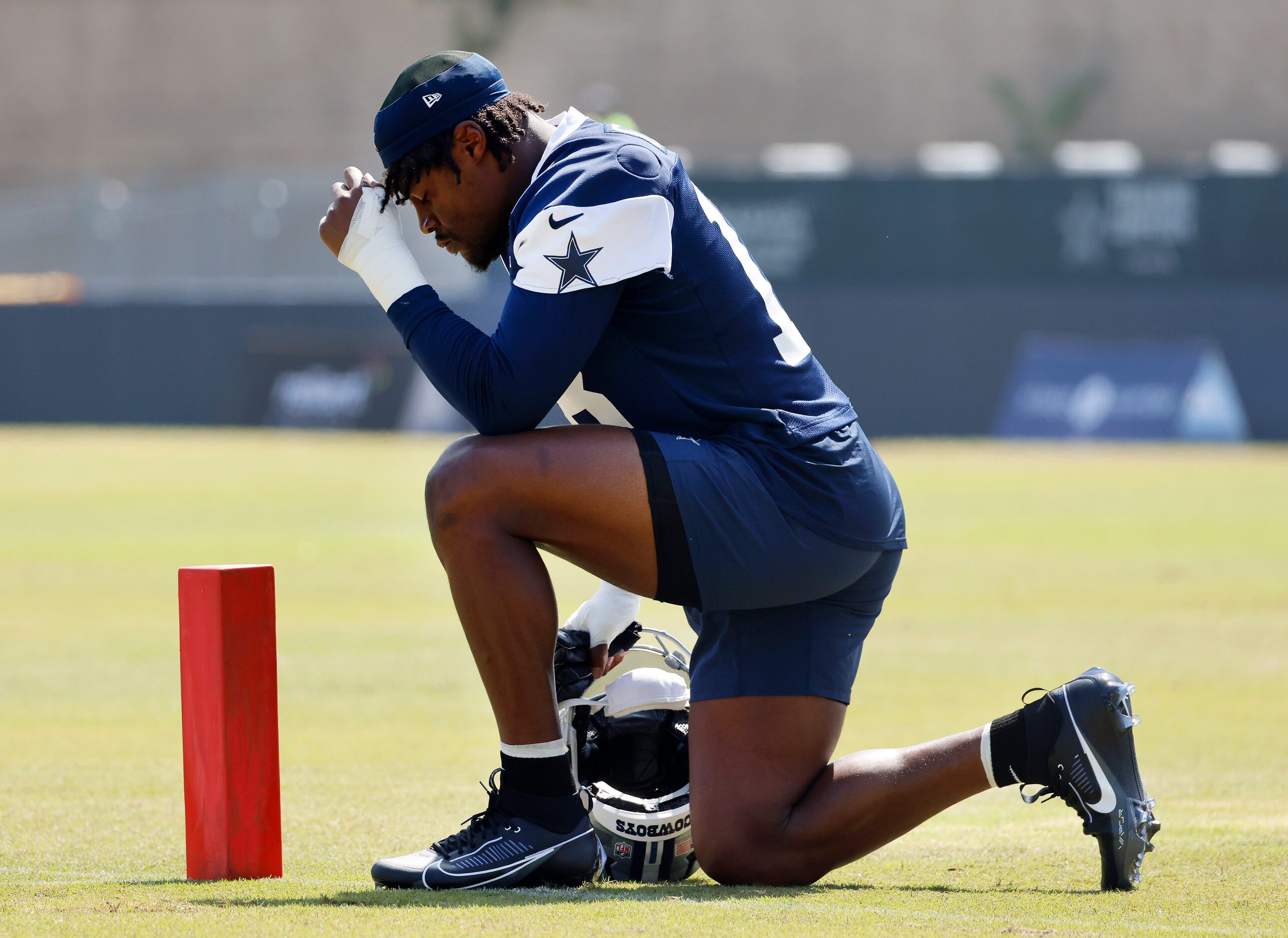 Dallas Cowboys linebacker Damone Clark (18) takes a knee at the end zone pylon before taking...