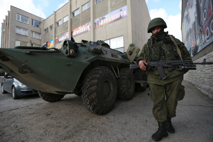 A soldier in an unmarked uniform stands guard outside the Ukrainian Military Prosecutor's...