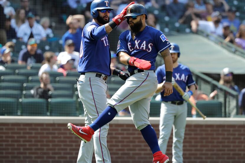 Texas Rangers' Nomar Mazara, left, and Rougned Odor, right, react after they both scored on...