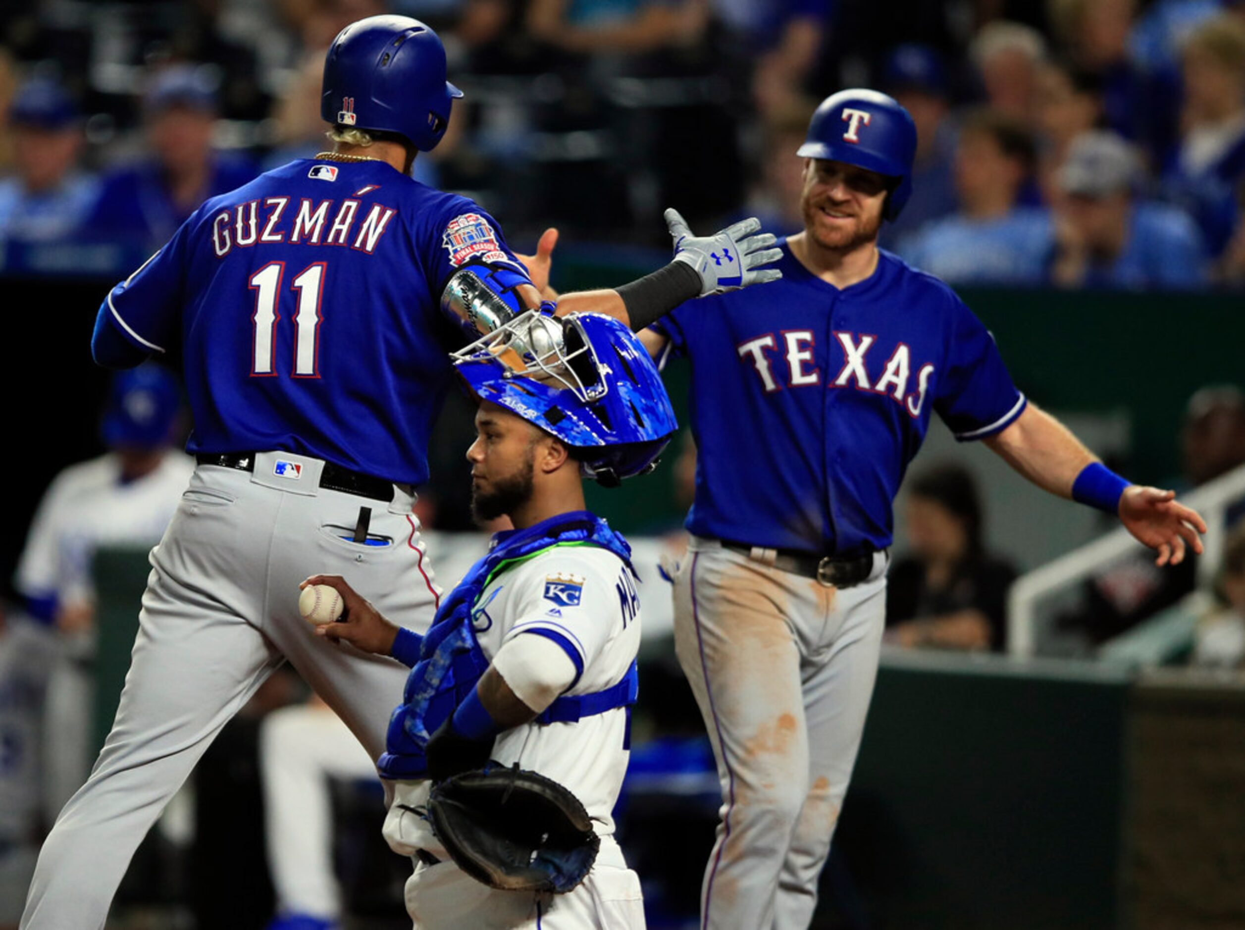 Texas Rangers' Ronald Guzman (11) celebrates his two-run home run with teammate Logan...