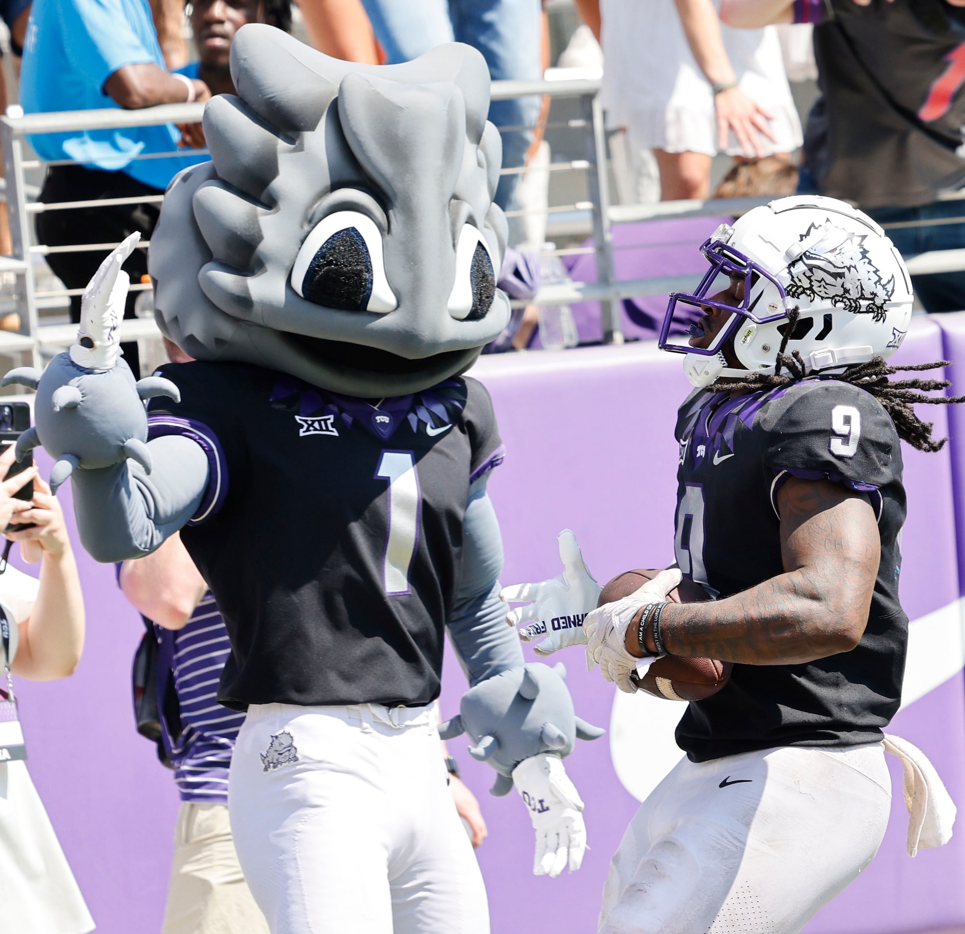 TCU Horned Frogs running back Emani Bailey (9) gets a high-five from TCU mascot SuperFrog...