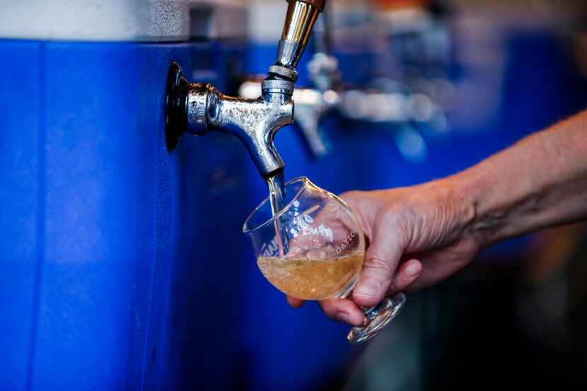 Main Street Fest volunteer Susan Dalebroux pours a glass of Ace Perry California Cider for a...