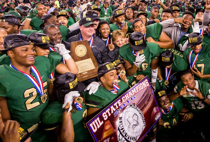 DeSoto head coach Todd Peterman clutches the championship trophy as he celebrates with his...