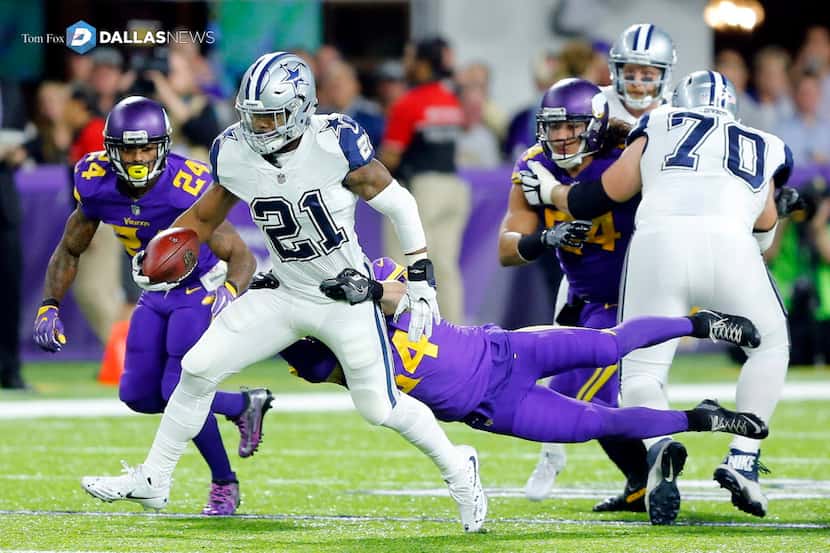 Dallas Cowboys running back Ezekiel Elliott (21) is dragged down by Minnesota Vikings strong...