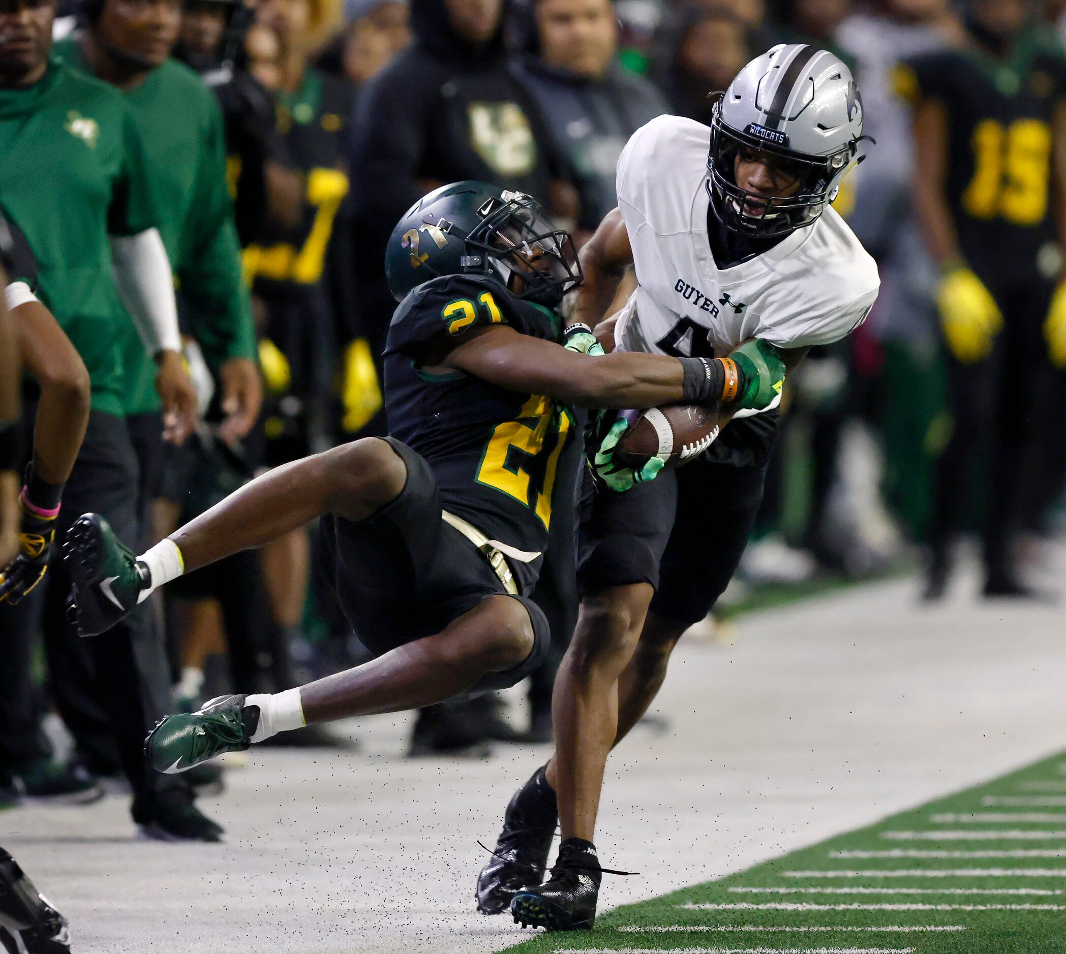 DeSoto Mario Buford (21) wrangles Denton Guyer wide receiver Josiah Martin (4) and spins him...