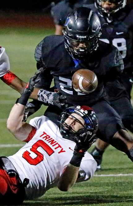 Trinity High School Toby Harrah (5) and Hebron High School free safety Darius Snow (23)...