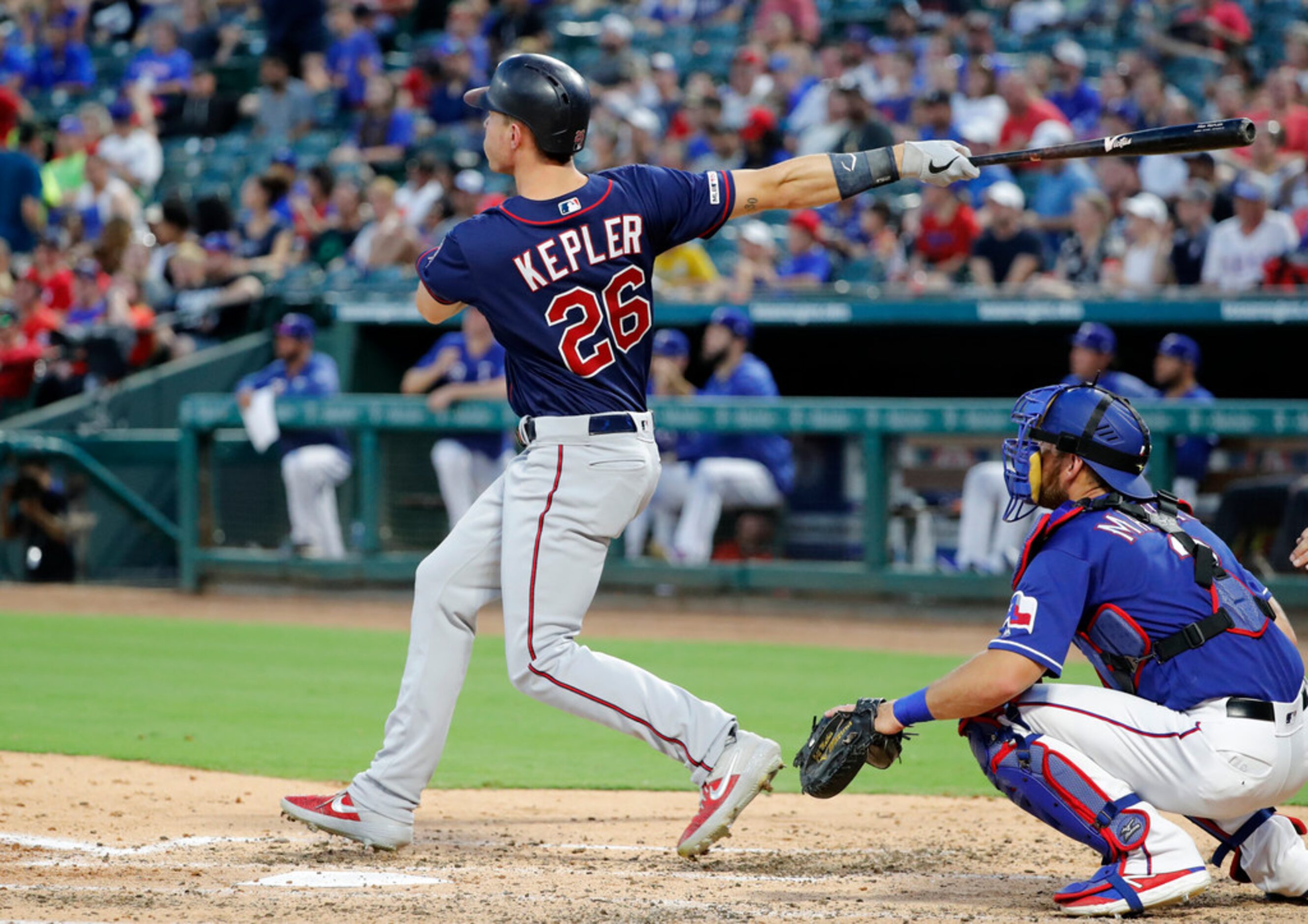 Minnesota Twins' Max Kepler (26) follows through on a two-run home run next to Texas...