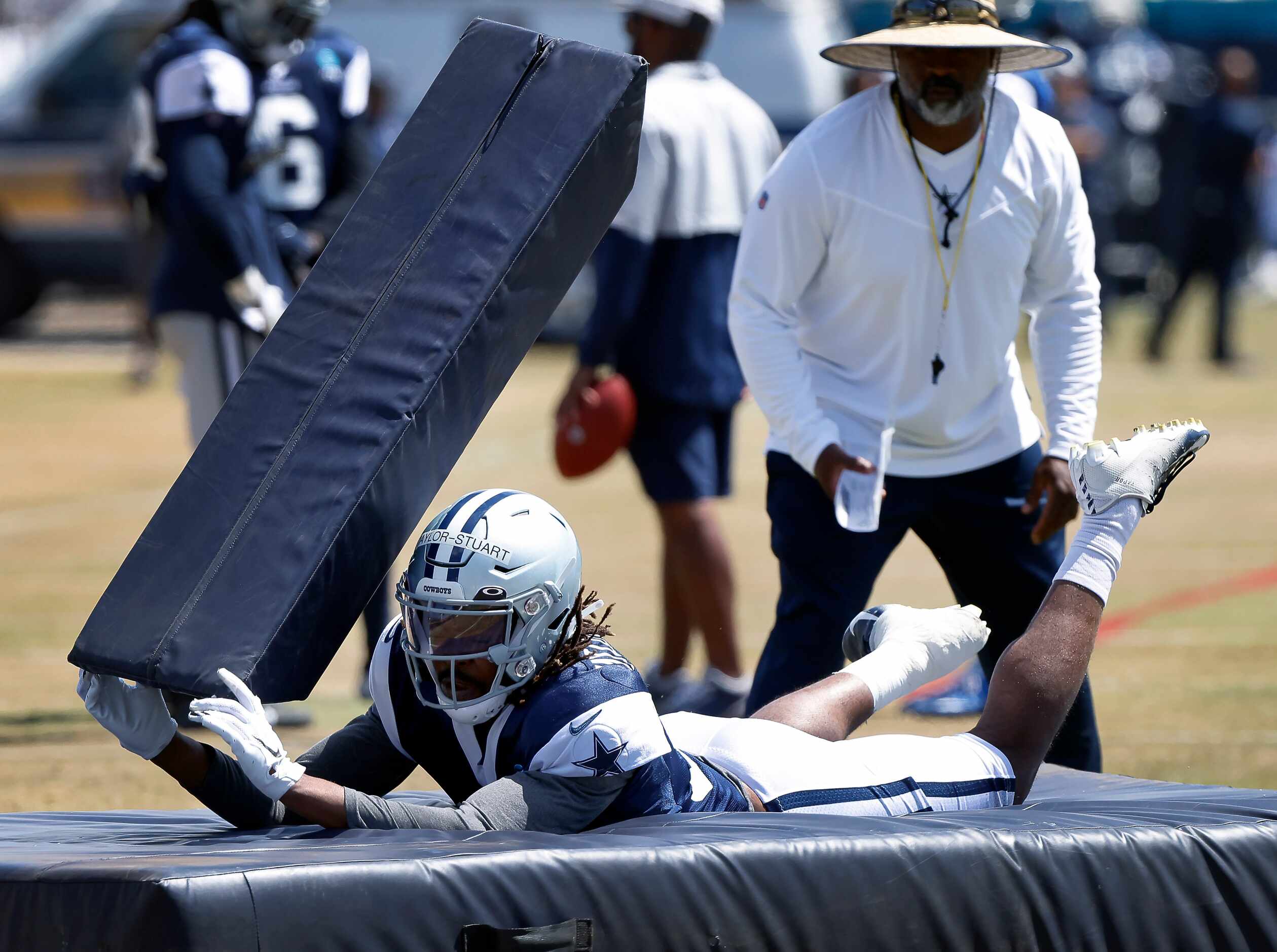 Dallas Cowboys cornerback Isaac Taylor-Stuart (36) dives and tackles a blocking dummy and...