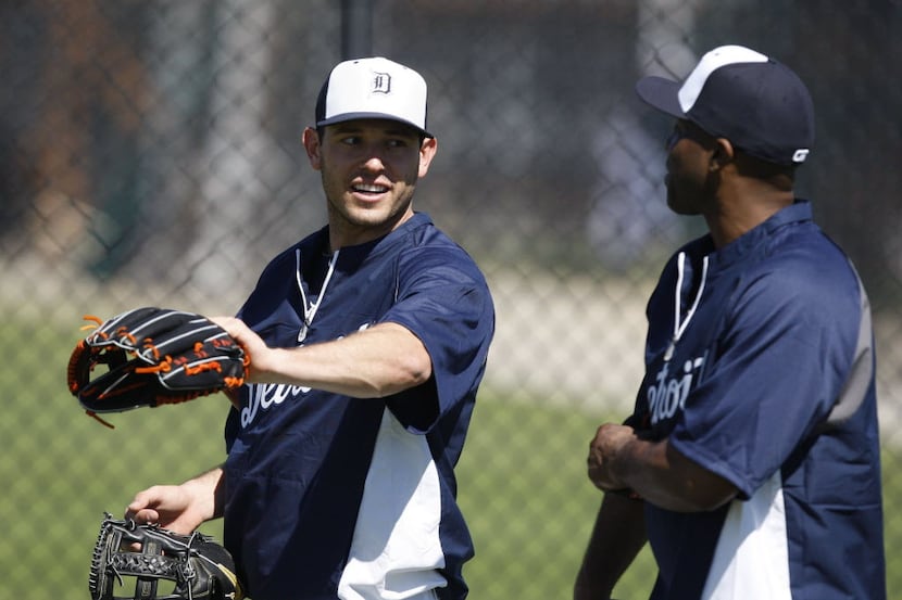 Detroit Tigers' Ian Kinsler, left, checks out Torii Hunter's glove as they walk back to the...
