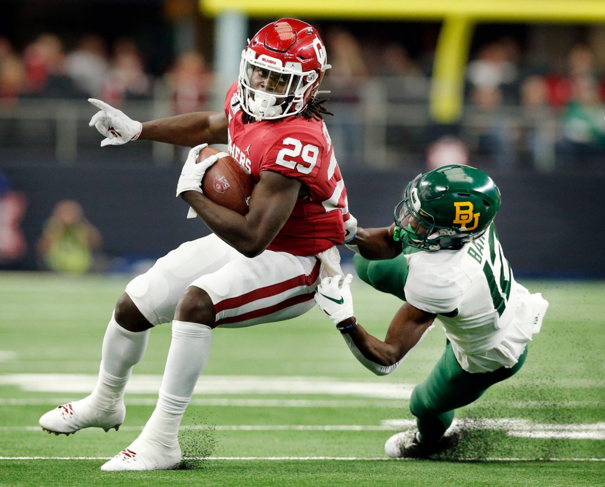 Baylor Bears cornerback Kalon Barnes (12) brings down Oklahoma Sooners running back...