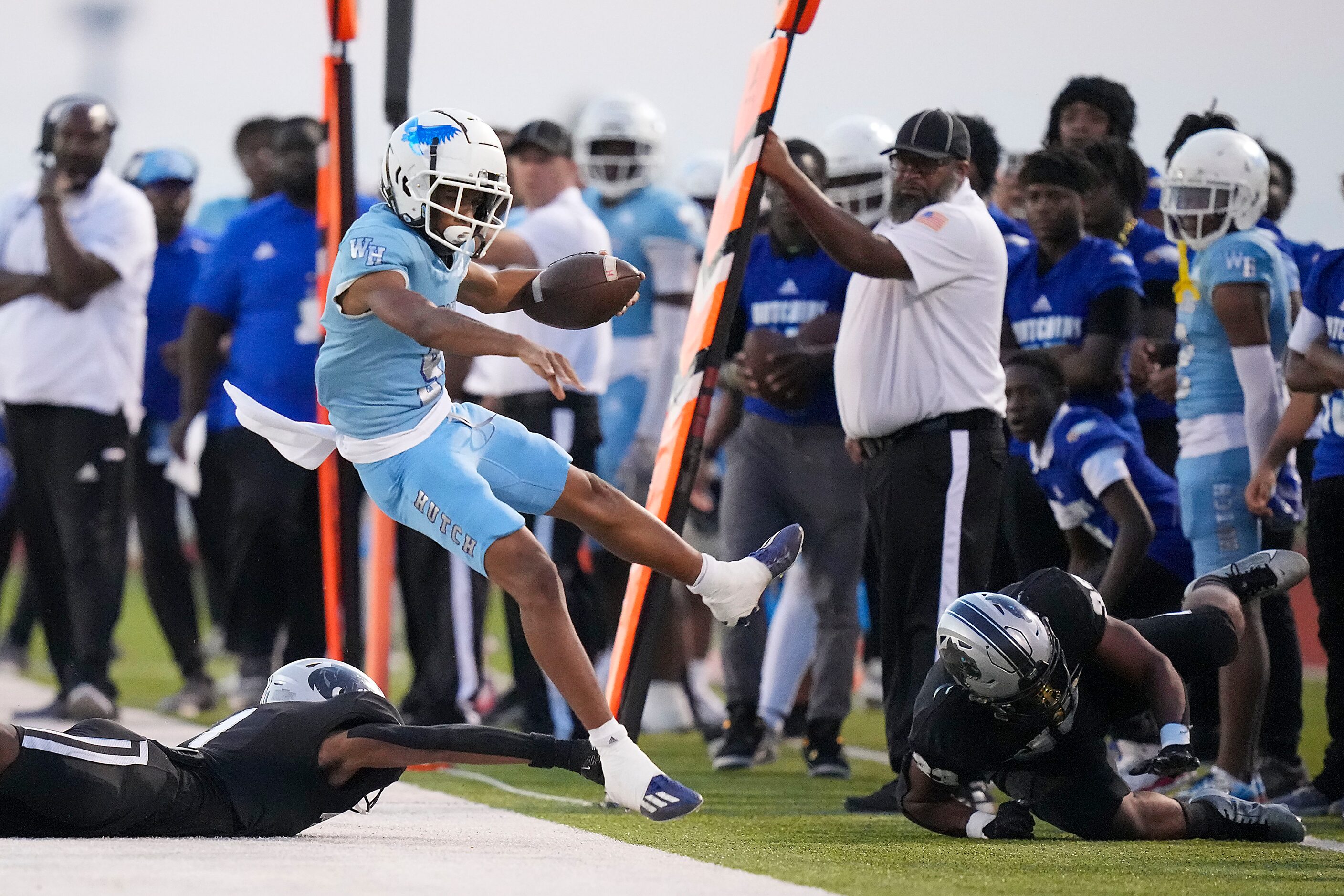 Wilmer-Hutchins quarterback Tamajae Mcmillon (9) is knocked out of bounds during the first...