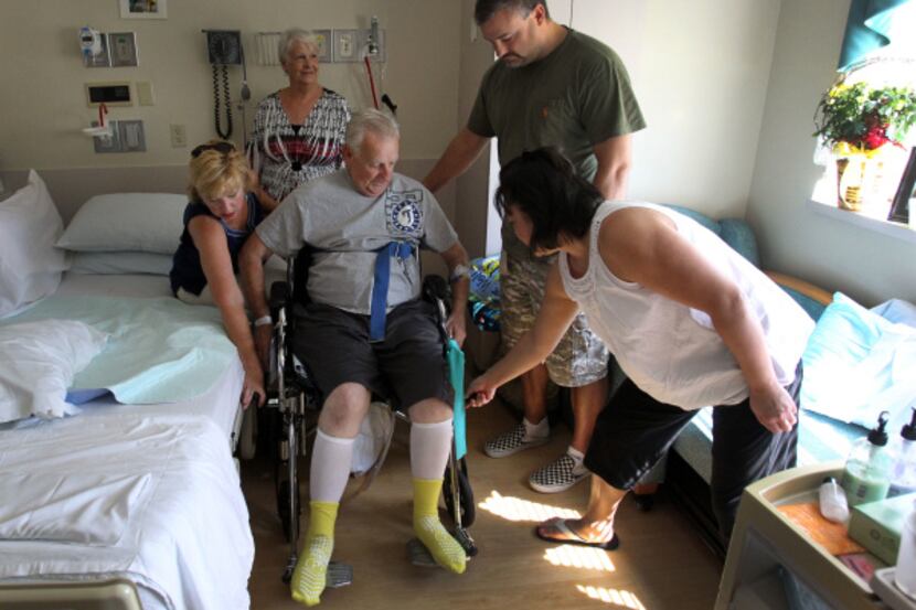 Rayford Fields (center) gets assistance with his wheelchair from  daughter Karen Gordon...