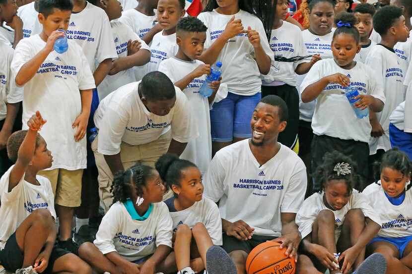 Harrison Barnes, posing here with kids at his basketball camp, is out for the home opener...