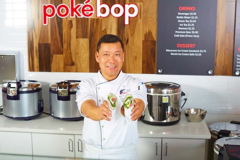 Chef Tommy Hwang holds the Poke Ritto, a burrito filled with poke, at Poke Bop. 
