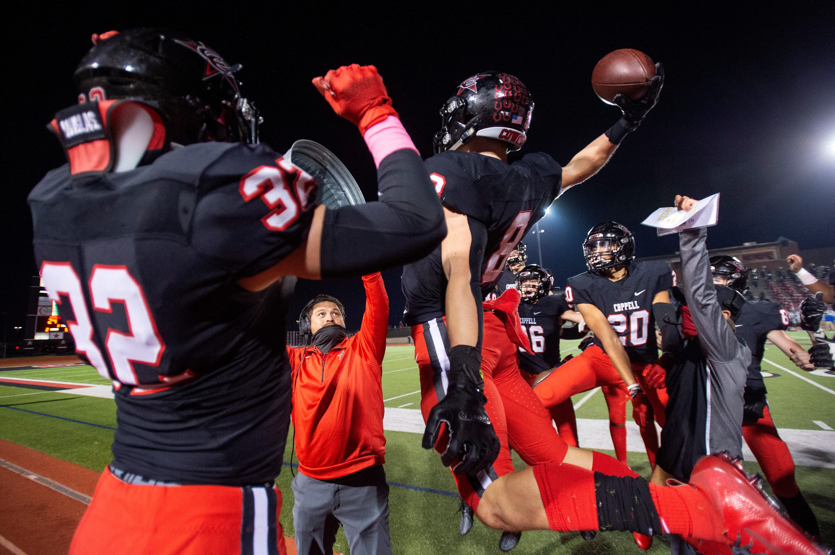 Senior defensive back Cameron Peters (8) slams the ball into a metal trashcan held by a...