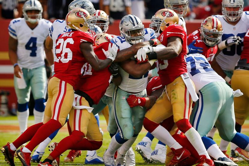 Dallas Cowboys running back Ezekiel Elliott (21) fights for more yards as he is surrounded...