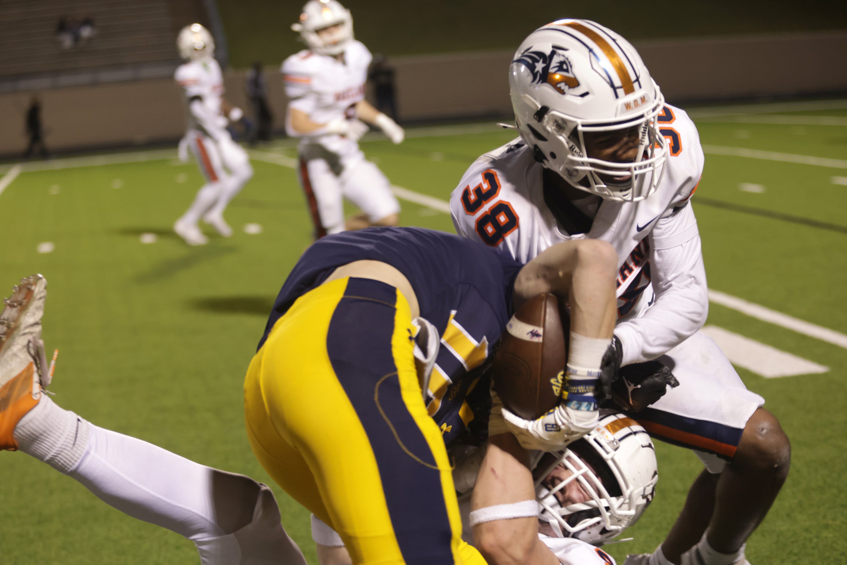 Highland Park's Brandon Lilly gets taken down by Frisco Wakeland defenders in a football...