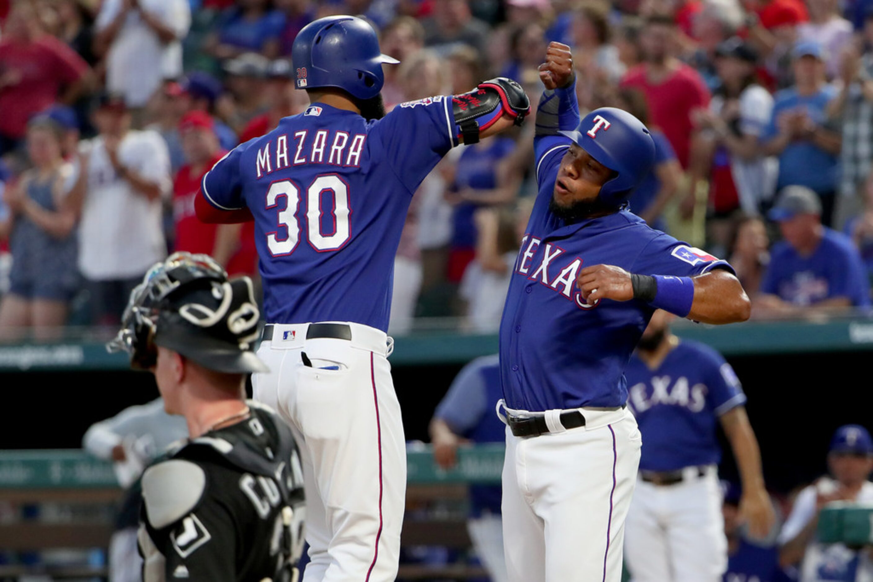 ARLINGTON, TEXAS - JUNE 22: Nomar Mazara #30 of the Texas Rangers celebrates with Elvis...