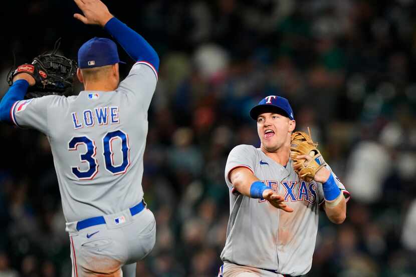 Texas Rangers first baseman Nathaniel Lowe (30) jumps up to celebrate with third baseman...