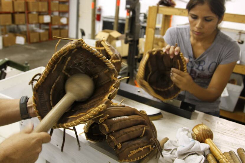 Maria Cedillo (right) shapes a newly handmade Nokona baseball glove  at Nokona Athletic...