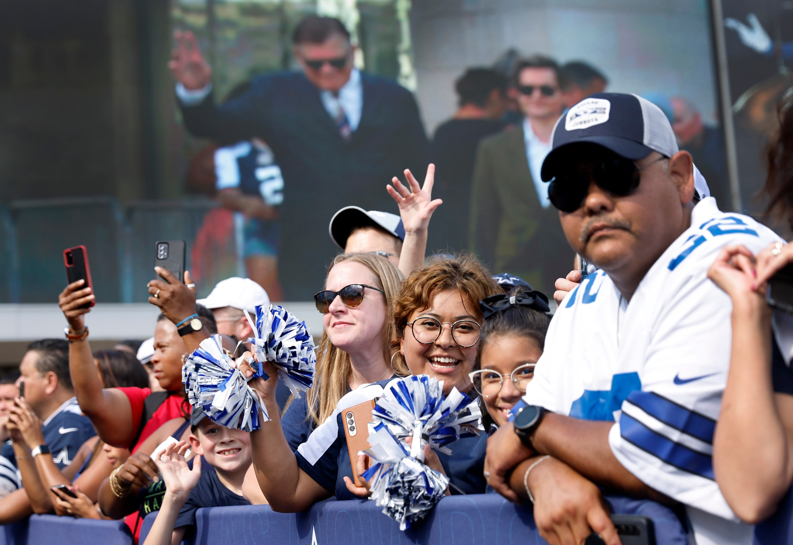 Dallas Cowboys fans watch as current and former players and coaches arrive on the blue...