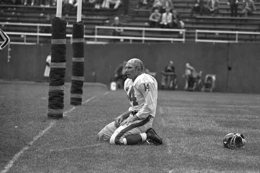 In this Sept. 20, 1964 file photo, New York Giants' Y.A. Tittle squats on the field after...