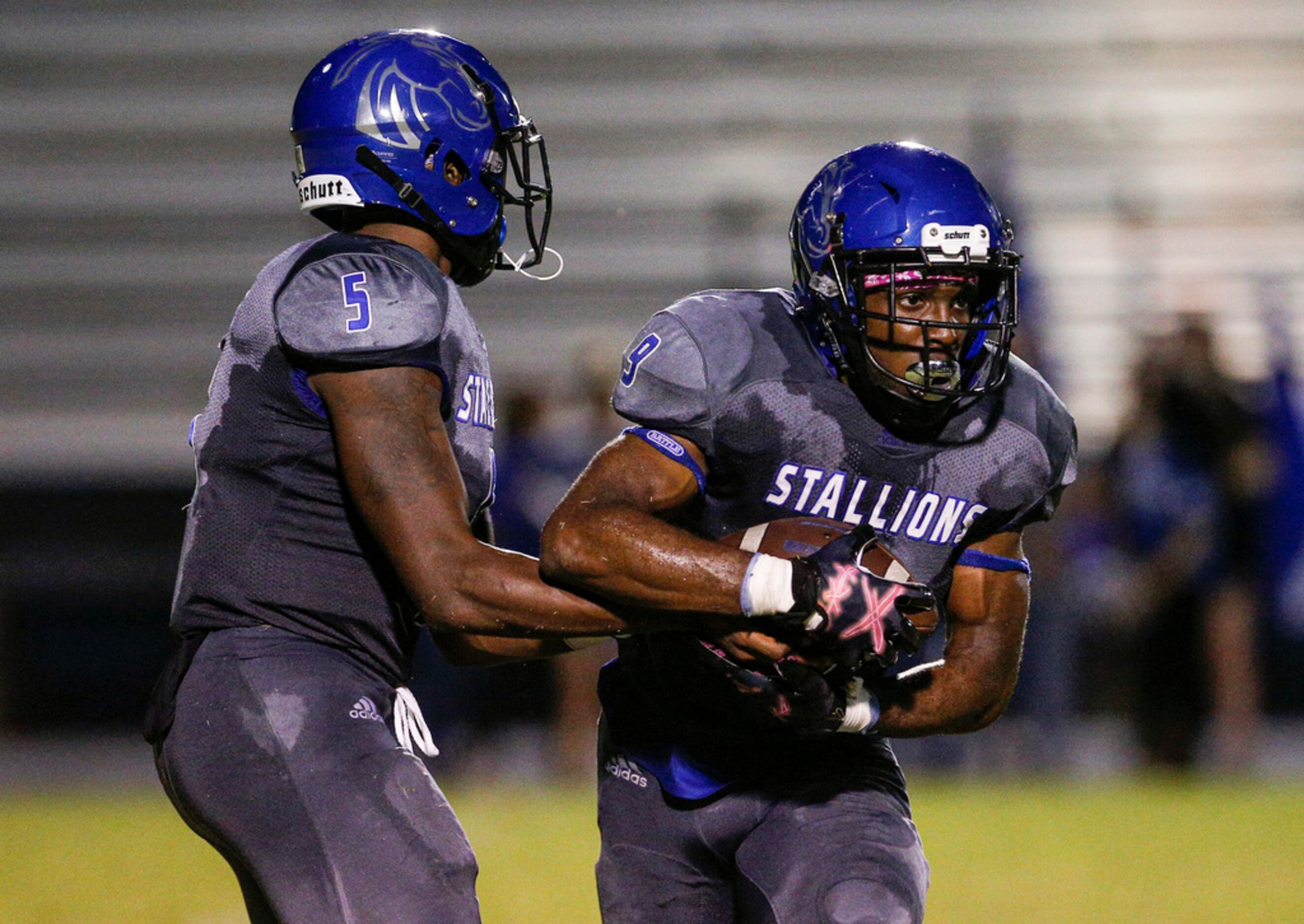 TXHSFB North Mesquite senior quarterback Kamaury Thompson (5) hands the ball off to senior...