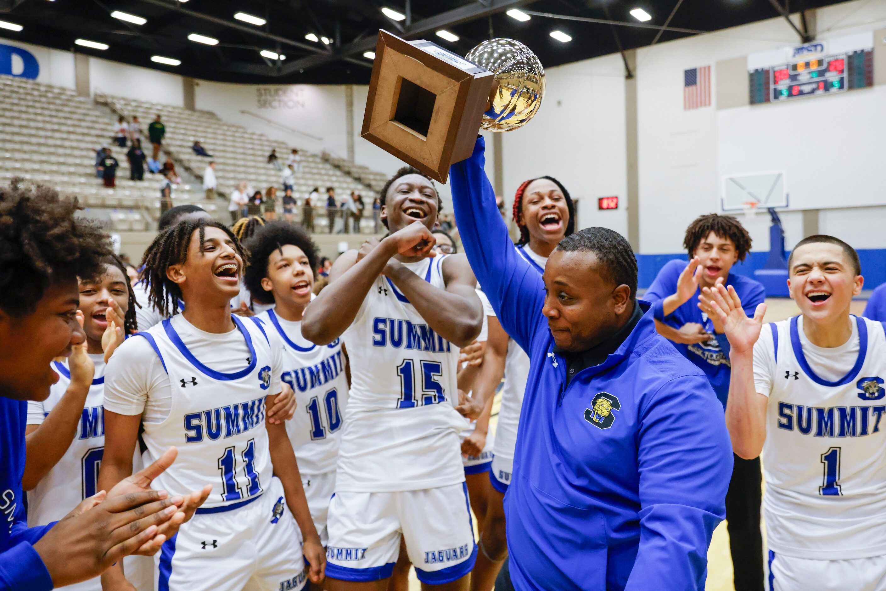 Mansfield Summit head coach Emund Prichett lifts the trophy as his team celebrate the...