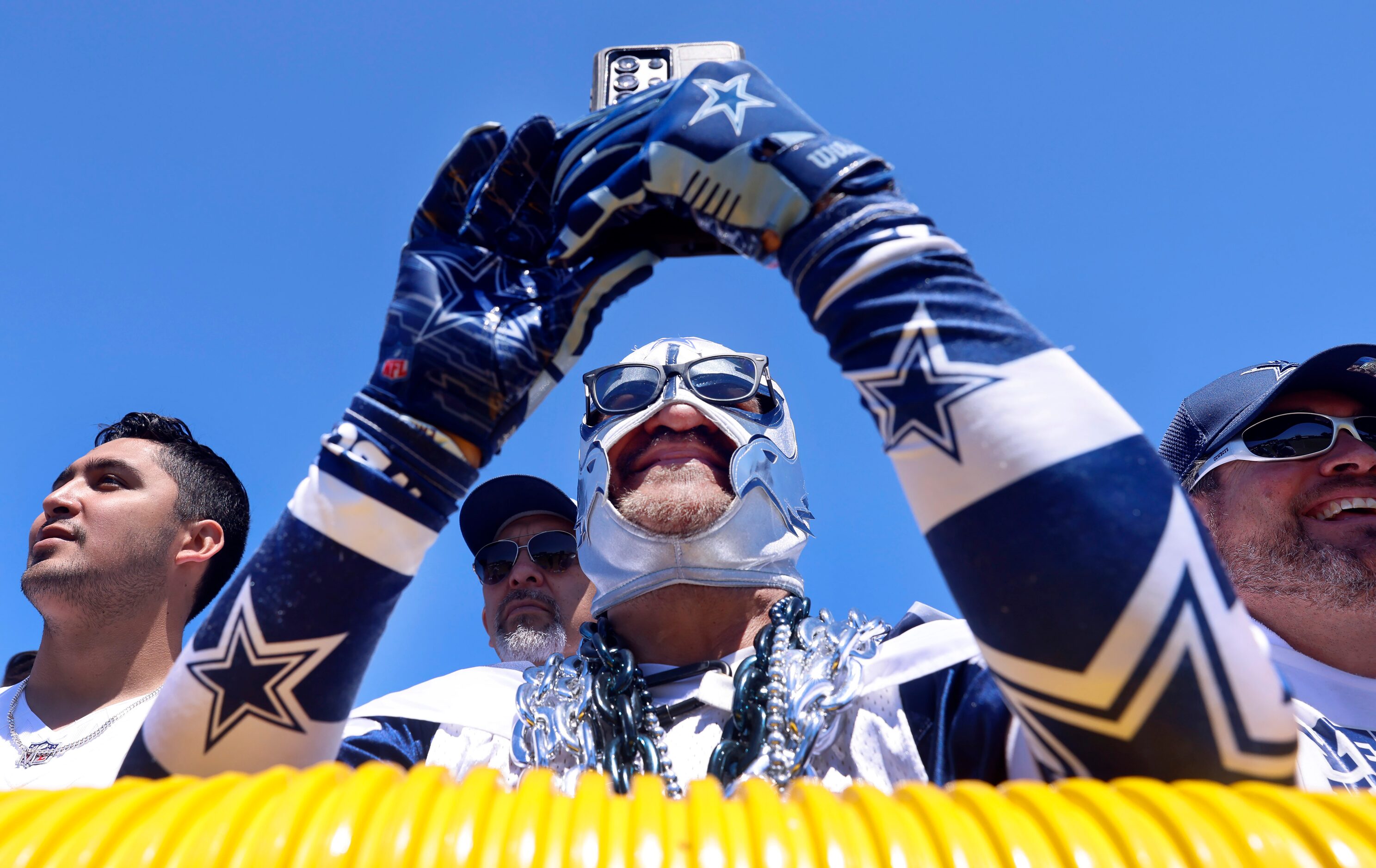 Fan Carlos Santa Cruz of Salinas, California records the Dallas Cowboys warming up during a...