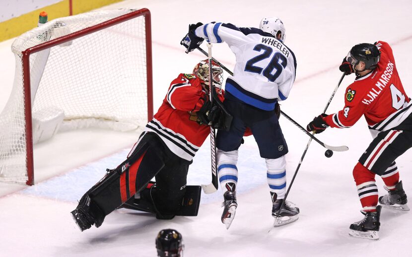 Chicago Blackhawks goalie Scott Darling, left, and defenseman Niklas Hjalmarsson (4) deny...