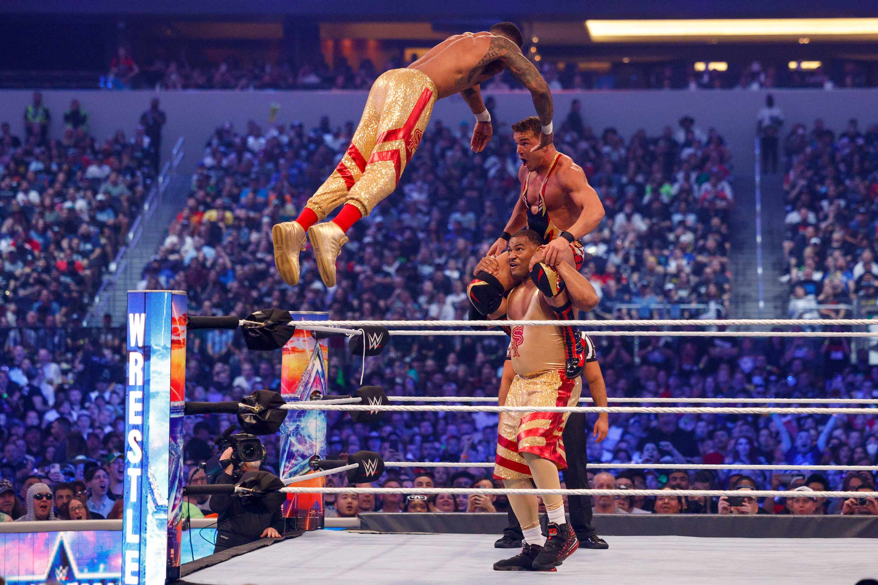 Montez Ford leaps onto Chad Gable and teammate Angelo Dawkins (bottom) during a match at...