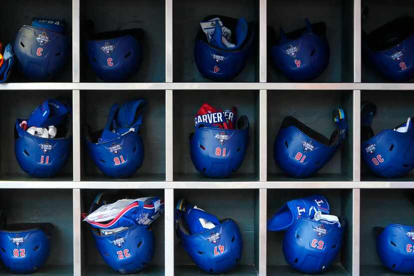 Texas Rangers batting helmets with World Series stickers on the back are seen in the dugout...